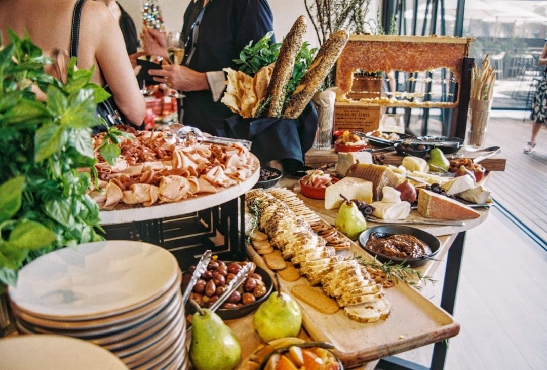 Reichhaltiges Frühstücksbuffet mit Käse, Aufschnitt, Brot, Obst und Kräutern